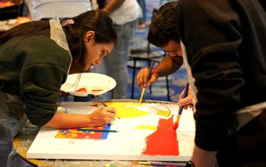 Two people painting colourful artwork together